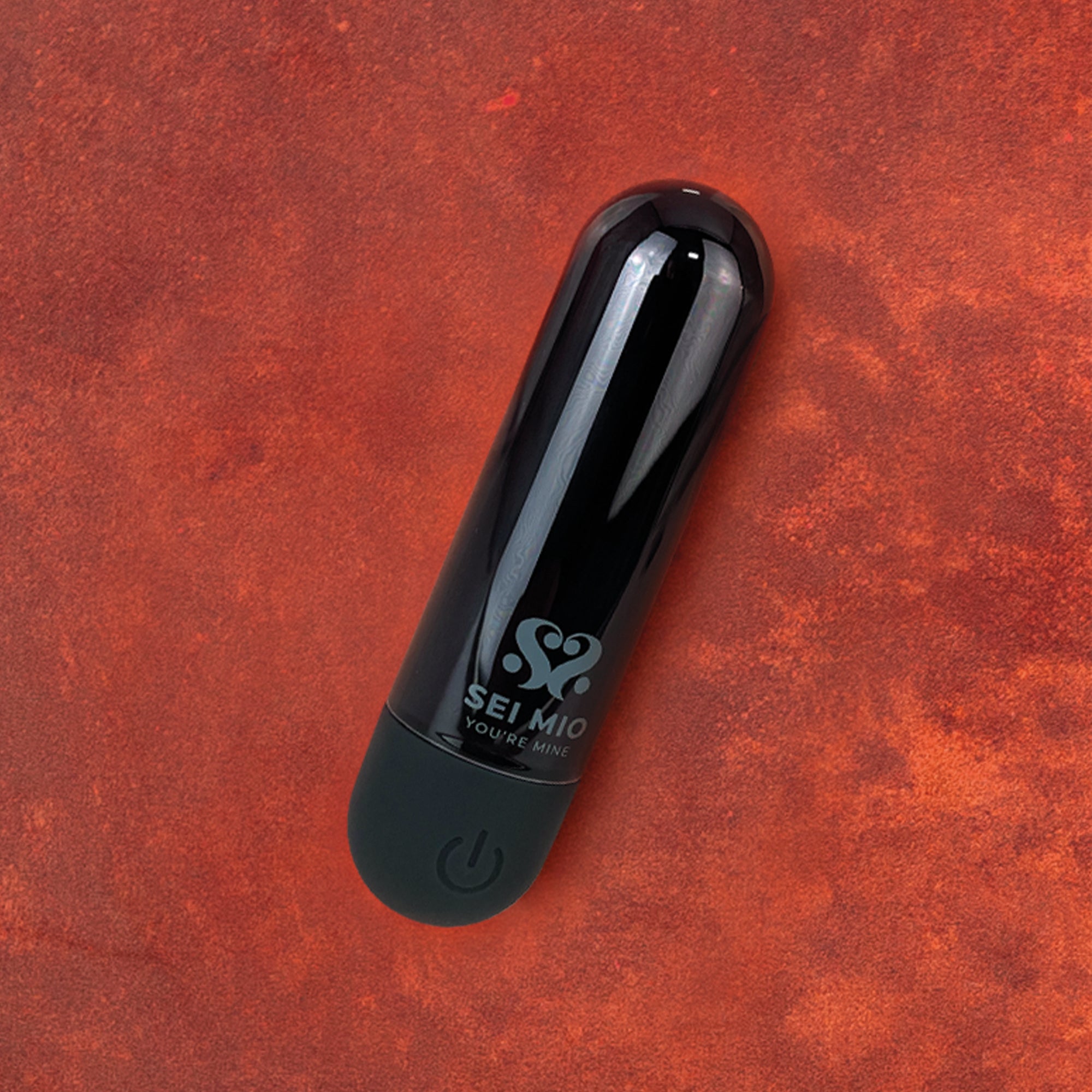 Black bullet vibrator with 'Sei Mio' branding on a red textured background